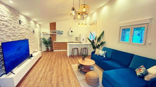 sala de estar con sofá azul y TV de pantalla grande en Mini Villa Indépendante à 350m de la mer (LAX) en Lucciana