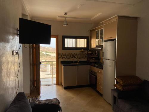 a kitchen with a couch and a kitchen with a refrigerator at House of banana beach aourir in Aourir