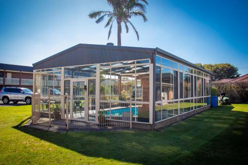 una casa de cristal con piscina. en Arkana Motor Inn & Terrace Apartments, en Mount Gambier