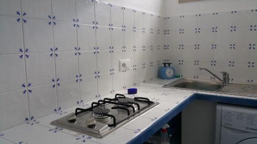 a stove top in a kitchen with blue and white tiles at La Casetta in Capri