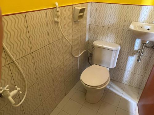 ein kleines Bad mit WC und Waschbecken in der Unterkunft Xylla Guesthouse in Siquijor
