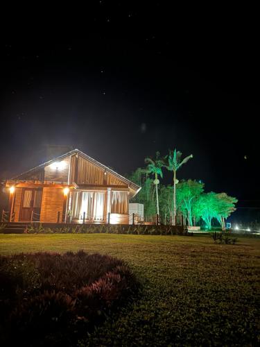 uma casa é iluminada à noite com luzes verdes em Mirador da Montanha em Praia Grande