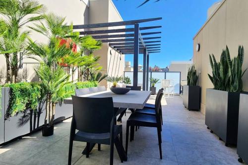 a table and chairs on a balcony with plants at Penthouse with Private Terrace, Parking + 2 Pools in Sydney