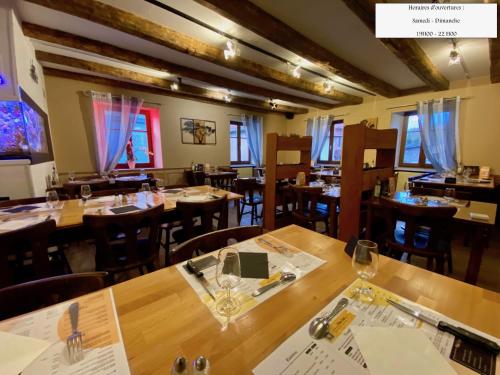 une salle à manger avec des tables et des chaises en bois dans l'établissement L'estaminet De La Vallée, à Schwartzbach