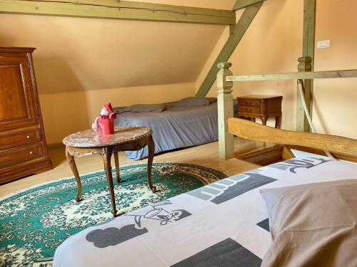 - une chambre avec un lit, une table et un lit dans l'établissement L'estaminet De La Vallée, à Schwartzbach