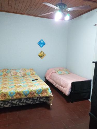 Un dormitorio con dos camas y un ventilador de techo. en Mer Departamento, en Resistencia