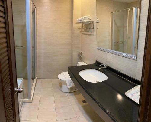 a bathroom with a sink and a toilet at Home Full Hotel in Jincheng