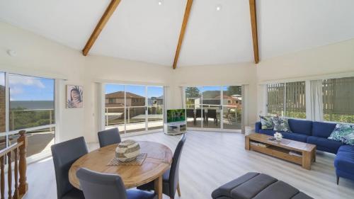 a living room with a blue couch and a table at Beach Break - Umina Beach Water Views in Umina
