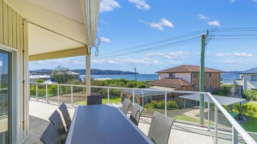 a patio with a table and chairs on a balcony at Beach Break - Umina Beach Water Views in Umina