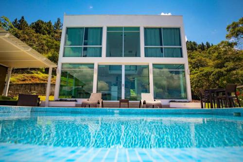 a house with a swimming pool in front of a house at Casa Moderna con piscina en las Montañas de Altos del María in Sorá