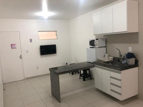 uma cozinha com uma bancada e um frigorífico em Apt05-06-07 no centro,a 800mts do pátio do forró em Caruaru
