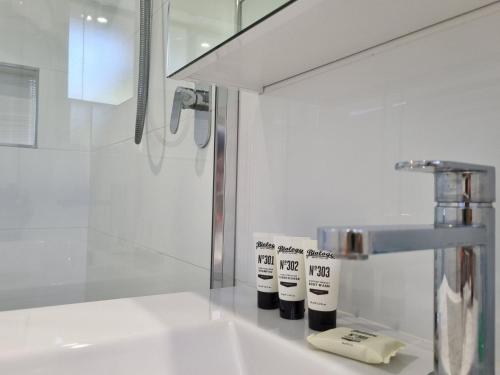 ein weißes Badezimmer mit einem Waschbecken und einem Wasserhahn in der Unterkunft Sunbakers in Forster
