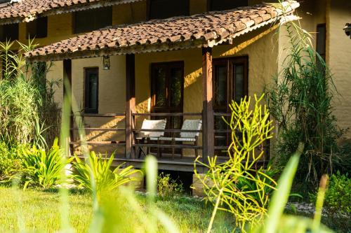a house with a porch with a chair on it at Tiger Tops Karnali Lodge in Bardia