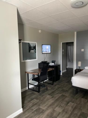 a hotel room with a desk and a bed at Motel St-Ambroise in Saint-Ambroise