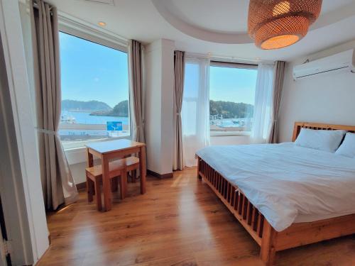 ein Schlafzimmer mit einem großen Bett und einem großen Fenster in der Unterkunft Seogwiporto in Seogwipo