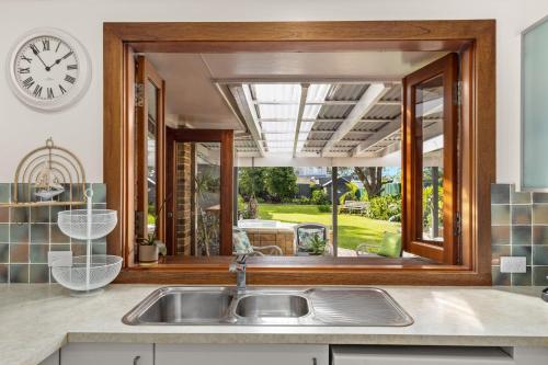 a kitchen with a sink and a large window at Crowford Sands by Experience Jervis Bay in Sanctuary Point