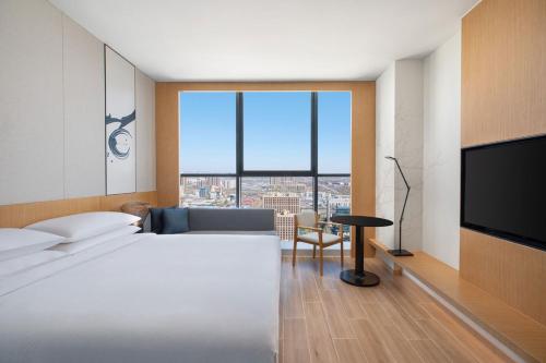 a hotel room with a bed and a large window at Fairfield by Marriott Shijiazhuang High-Tech Zone in Shijiazhuang