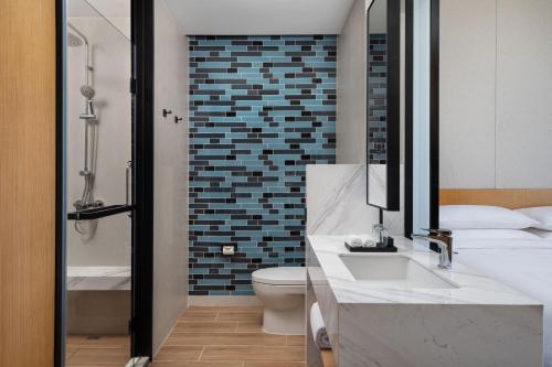 a bathroom with a sink and a toilet and a mirror at Fairfield by Marriott Shijiazhuang High-Tech Zone in Shijiazhuang
