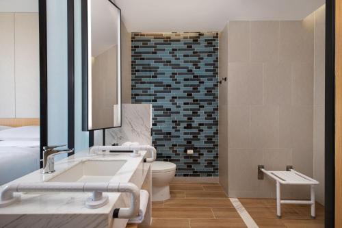 a bathroom with a sink and a toilet and a mirror at Fairfield by Marriott Shijiazhuang High-Tech Zone in Shijiazhuang