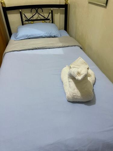 a bed with a white towel sitting on it at Janessa's Dwellery in Port Vila