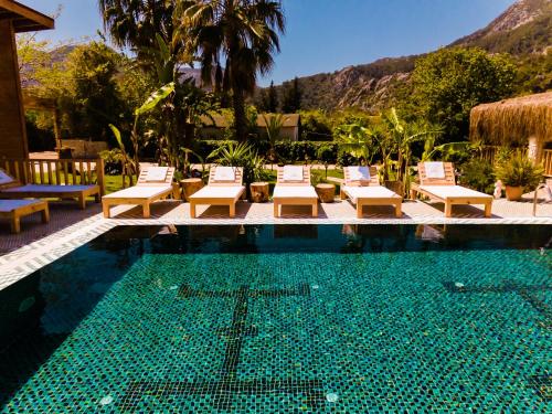 a swimming pool with lounge chairs and a resort at Naturelife Bungalows & SPA in Cıralı