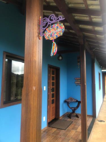 a hallway of a house with a blue wall and an umbrella at Vila Verde Chalés-Serro in Sêrro