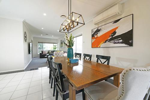 a dining room and living room with a wooden table and chairs at Doncaster Renovated 5BD/4BR Brick Home Parking WiFi in Doncaster