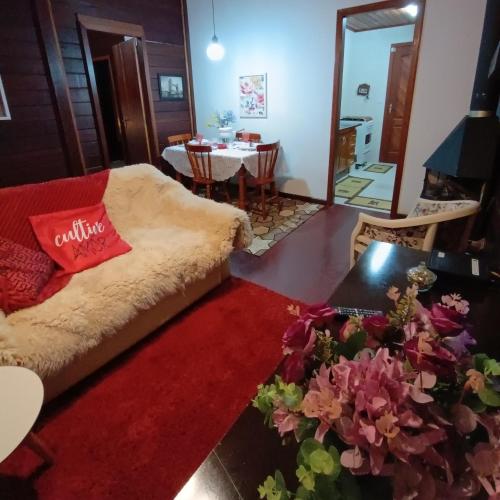 ein Wohnzimmer mit einem Sofa und einem roten Teppich in der Unterkunft Chalés Alto do Capivari in Campos do Jordão