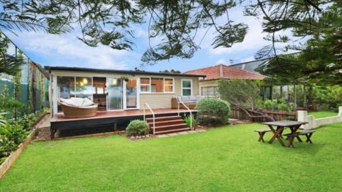 a house with a yard with a picnic table at Beach Shack - Waterfront Patonga in Patonga