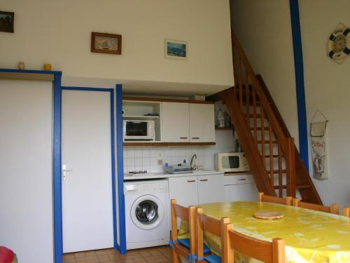 une cuisine avec une table et une machine à laver dans l'établissement Maison proche plage avec jardin et parking à La Tranche sur Mer - FR-1-22-164, à La Tranche-sur-Mer