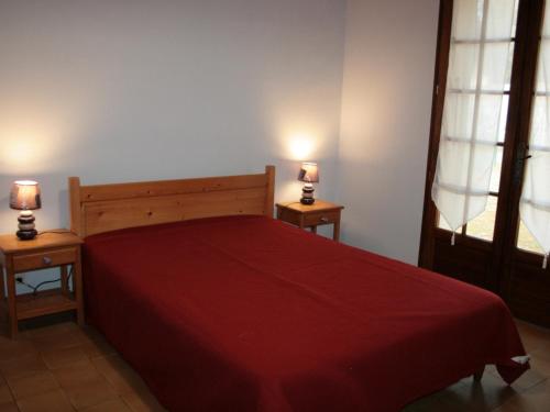 ein Schlafzimmer mit einem roten Bett mit zwei Lampen an zwei Tischen in der Unterkunft Maison La Tranche-sur-Mer, 2 pièces, 2 personnes - FR-1-22-218 in La Tranche-sur-Mer