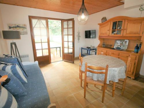 un salon avec une table et un canapé bleu dans l'établissement Maison à deux pas de la plage avec jardin privatif et tout confort - La Tranche-sur-Mer - FR-1-22-218, à La Tranche-sur-Mer