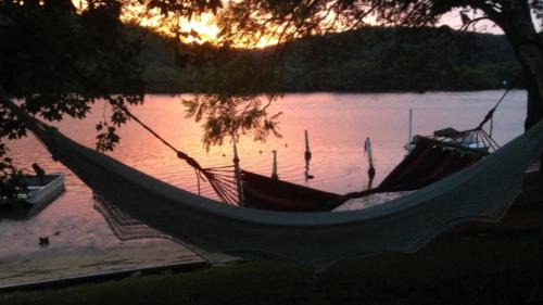 Patonga BeachにあるPatonga Sunset - Waterfront Holiday Houseの日没時の湖前のハンモック