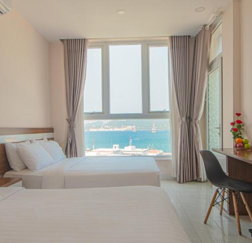 a hotel room with two beds and a large window at CLIFF HOUSE managed by DHG in Nha Trang