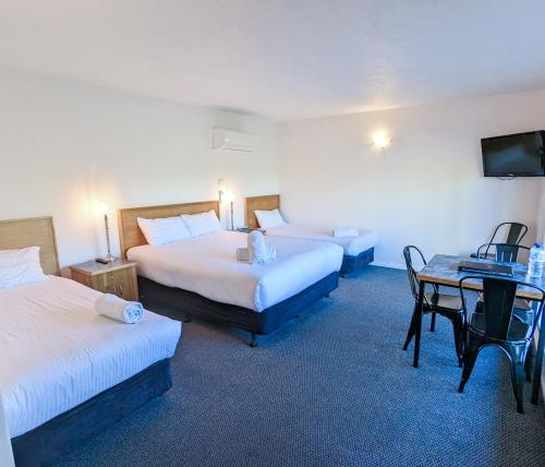 a hotel room with two beds and a table at Arkana Motor Inn & Terrace Apartments in Mount Gambier