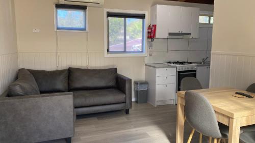 a living room with a couch and a table at Twin Dolphins Holiday Park in Tuncurry