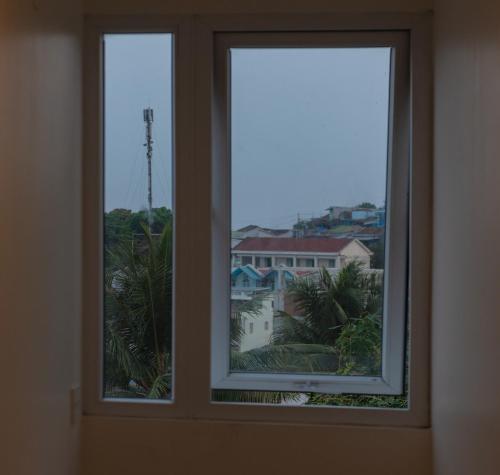 two windows in a room with a view of a building at Khách sạn CLIFFHOUSE NHA TRANG in Nha Trang