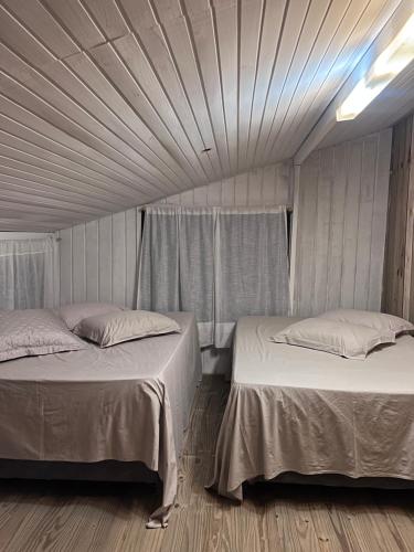 sypialnia z 2 łóżkami i drewnianą podłogą w obiekcie Sítio do Vô Pisco w mieście Camboriú