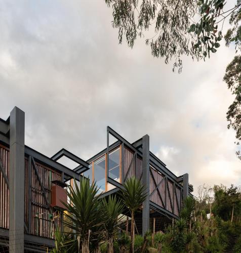 a house with glass walls and palm trees at Deluxe volcán Primeras suites colgantes del mundo in Baños