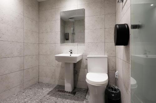 a bathroom with a toilet and a sink at Mariposa Hotel Songtan in Pyeongtaek