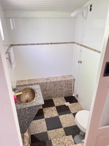a bathroom with a toilet and a sink at Sítio do Vô Pisco in Camboriú