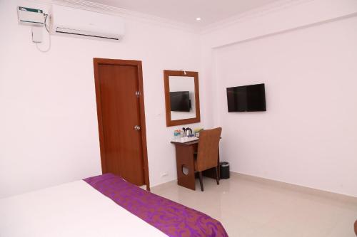 a bedroom with a bed and a mirror and a desk at Sbk Park Inn in Kanchipuram