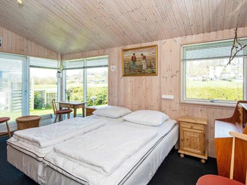 a bedroom with a large bed in a room with windows at Holiday home Aabenraa LXX in Aabenraa
