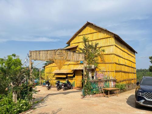 un granero de madera grande con motocicletas estacionadas frente a él en Bamboo Villa en Gia Nghĩa