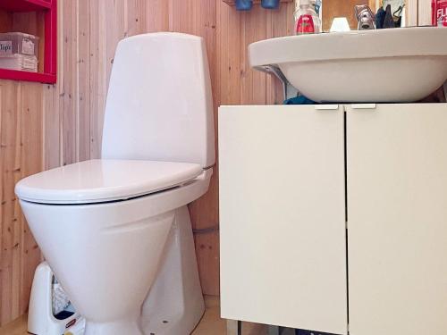 een badkamer met een wit toilet en een wastafel bij Holiday home GUSUM II in Gusum