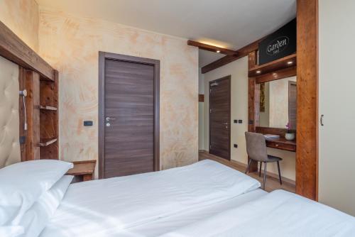 a hotel room with a bed and a desk at Garden Wellness Hotel S in Andalo