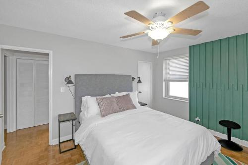 een slaapkamer met een wit bed en een plafondventilator bij 21st floor condo in the center of Atlanta in Atlanta