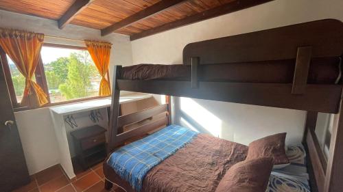 1 dormitorio con 2 literas y ventana en Hermosa casa en Villa de Leyva, en Villa de Leyva