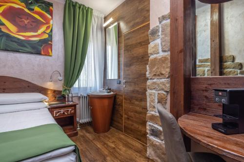 a hotel room with a bed and a stone wall at Garden Wellness Hotel S in Andalo