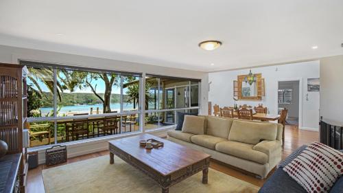 a living room with a couch and a table at Booker Bay Beach House Family Fun in Booker Bay